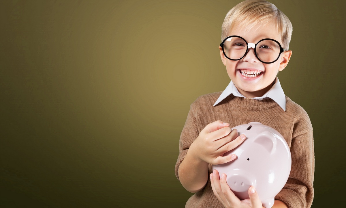 boy with glasses holding piggy bank