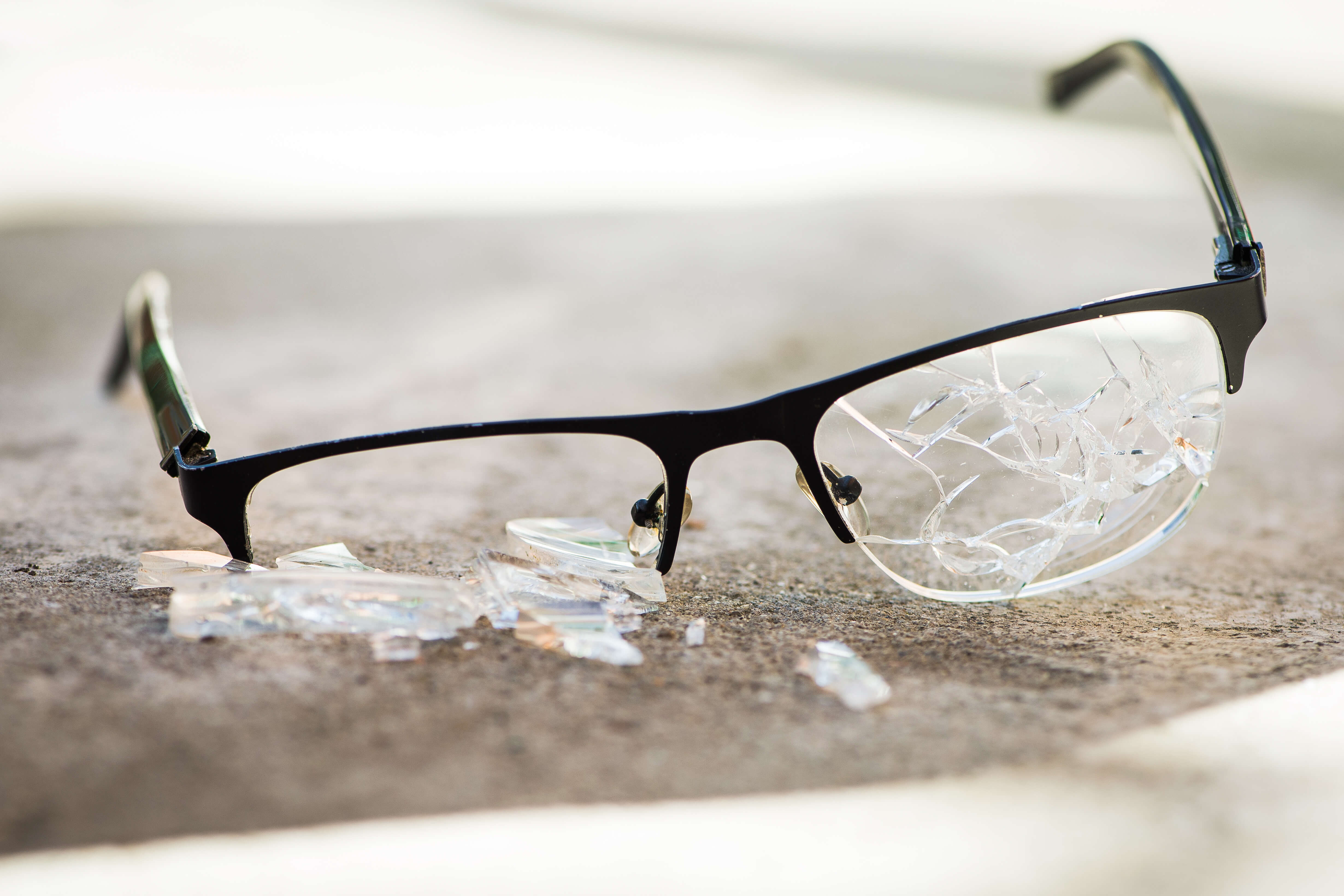broken eyeglasses on concrete pavement