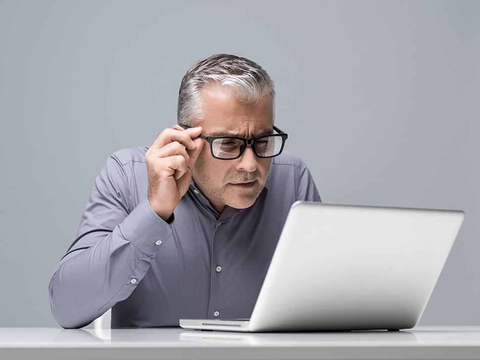 businessman looking at computer wearing glasses