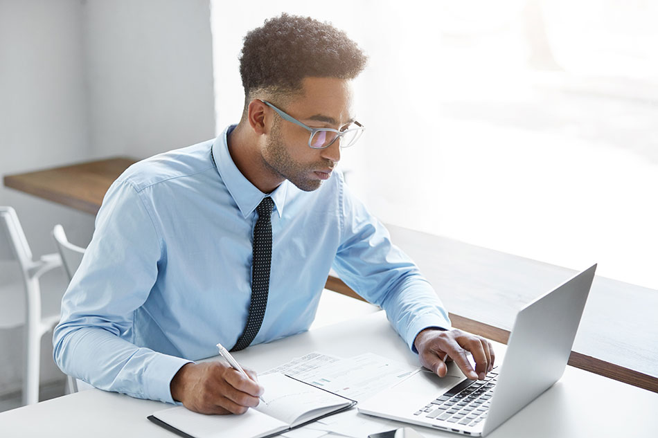 businessman wearing glasses working on laptop