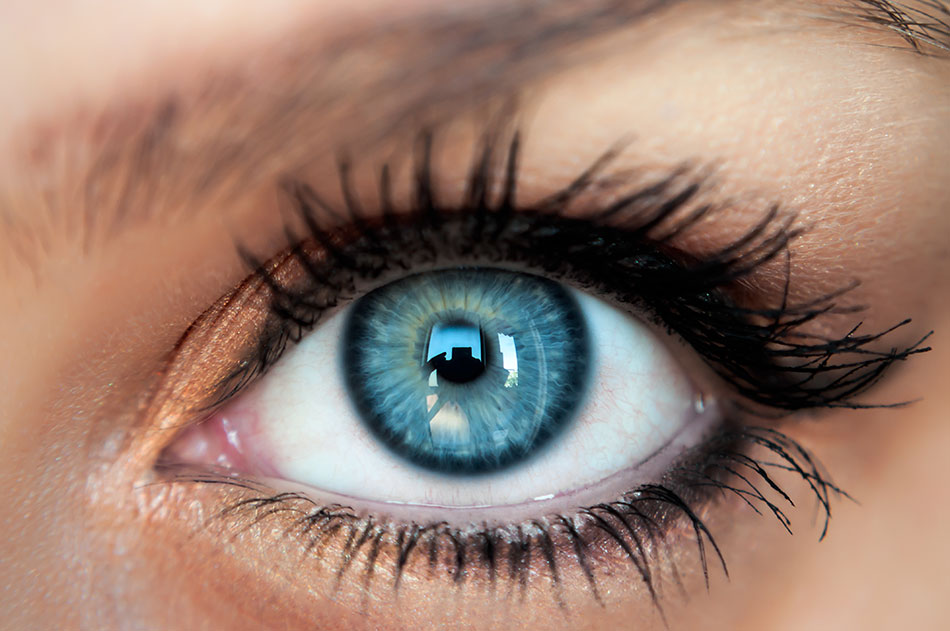 close up of woman’s eye with blue coloured contact lenses