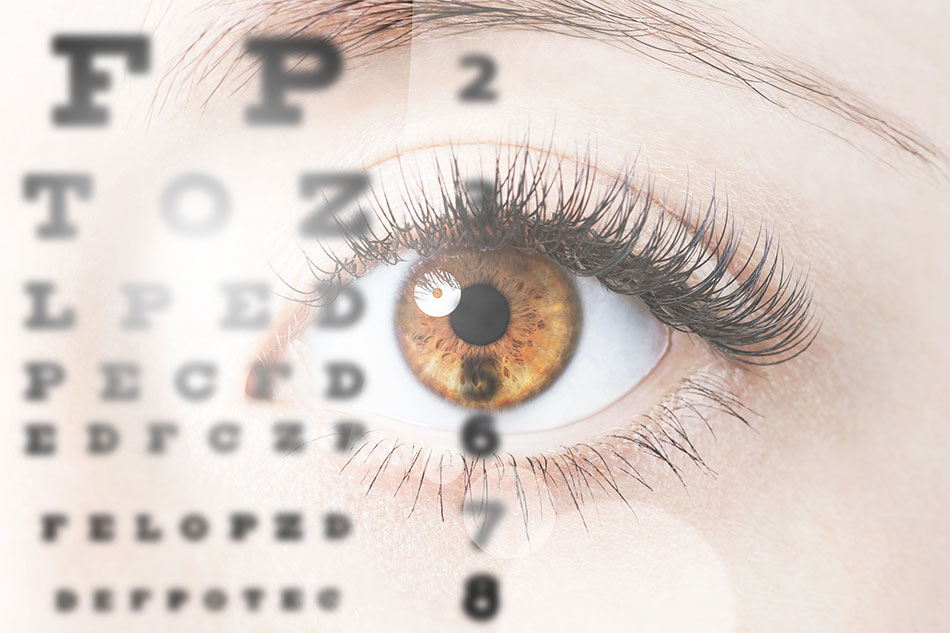 Close-up of brown eye with eye test chart