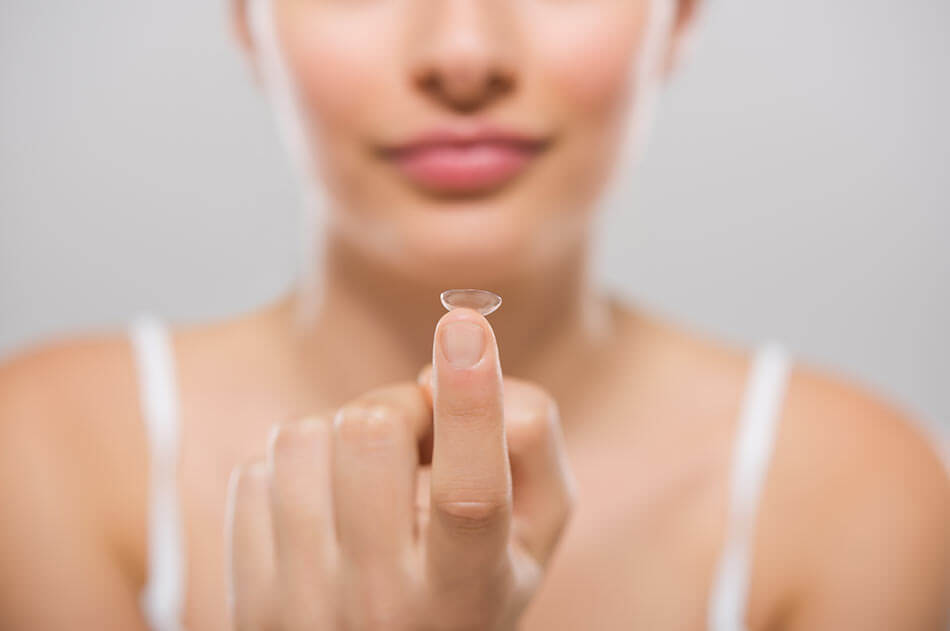 woman removing a disposable contact lens