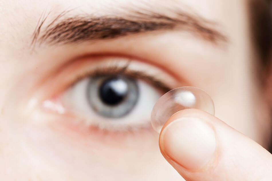 Woman inserting contact lens to see without glasses
