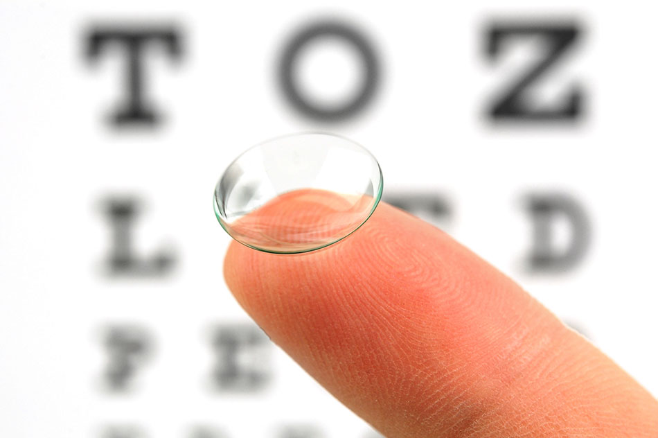 contact lens on finger and eye test chart