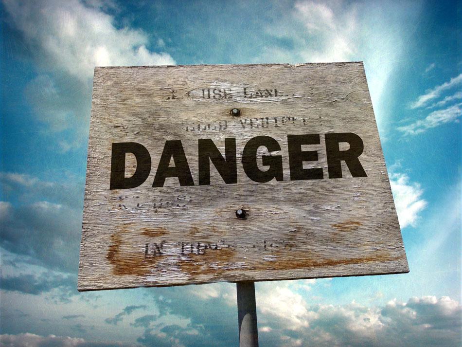 danger wooden sign with blue sky and clouds in background