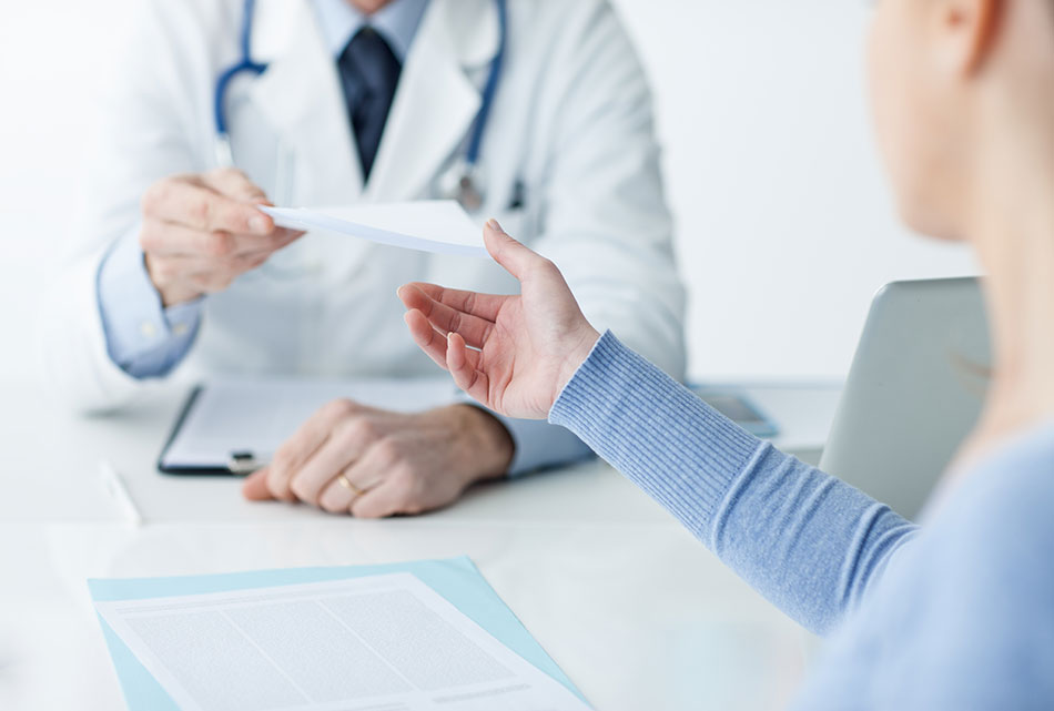 doctor handing contact lens prescription to woman