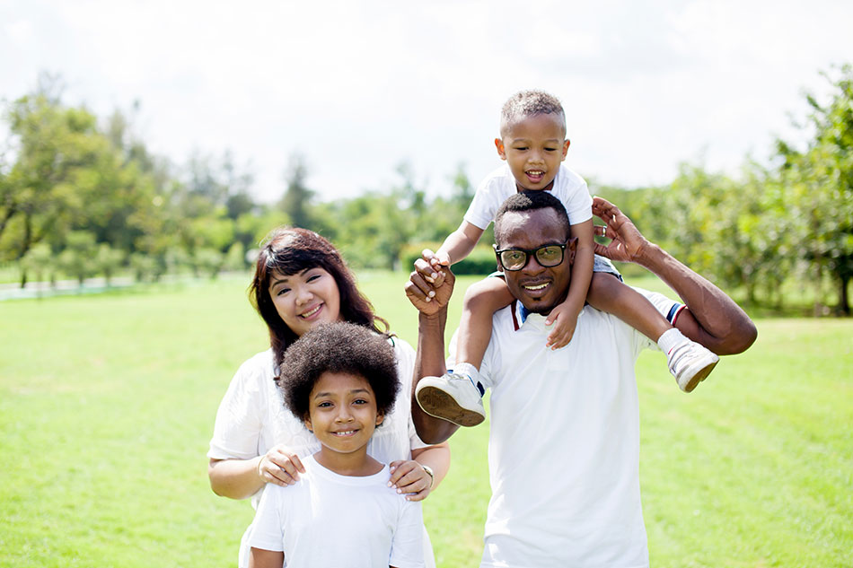 family smiling in the outdoors