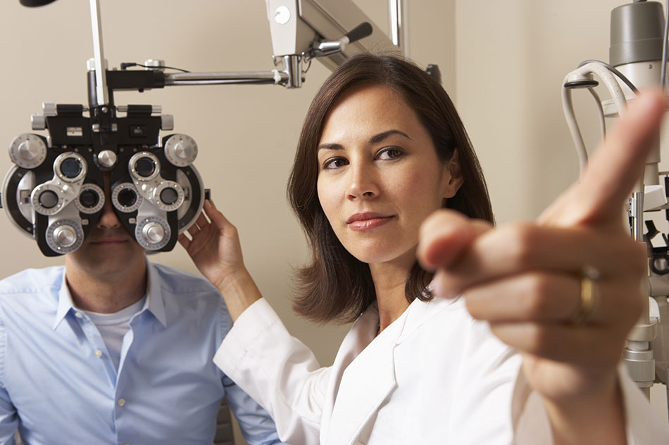 female eye doctor giving man an eye test