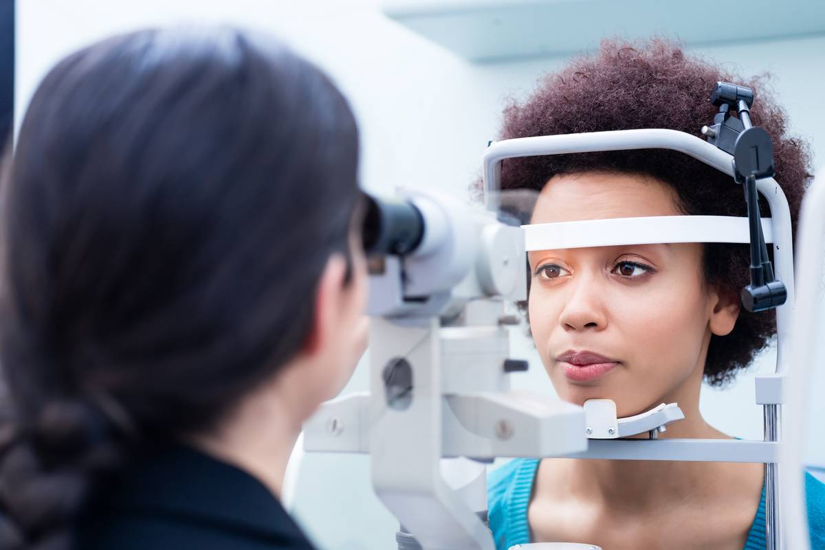Female optometrist examining young woman’s eyes