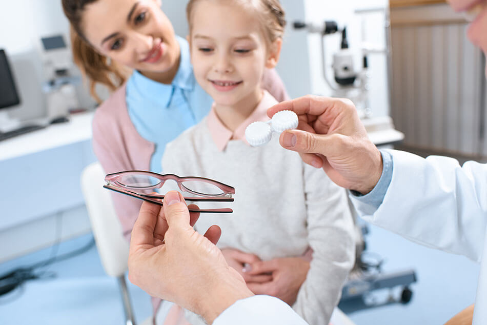 Girl with mother choosing between contact lenses and glasses