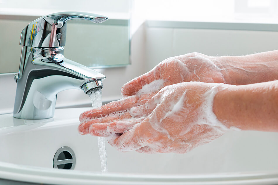 soapy hands under running tap