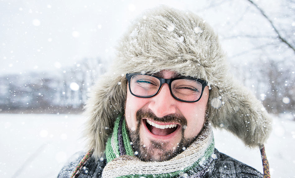 happy man wearing glasses in snow