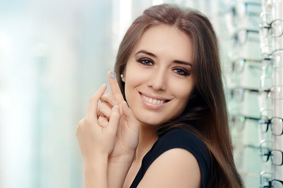 Woman happy to keep her contact lenses breathing, holding one on her finger