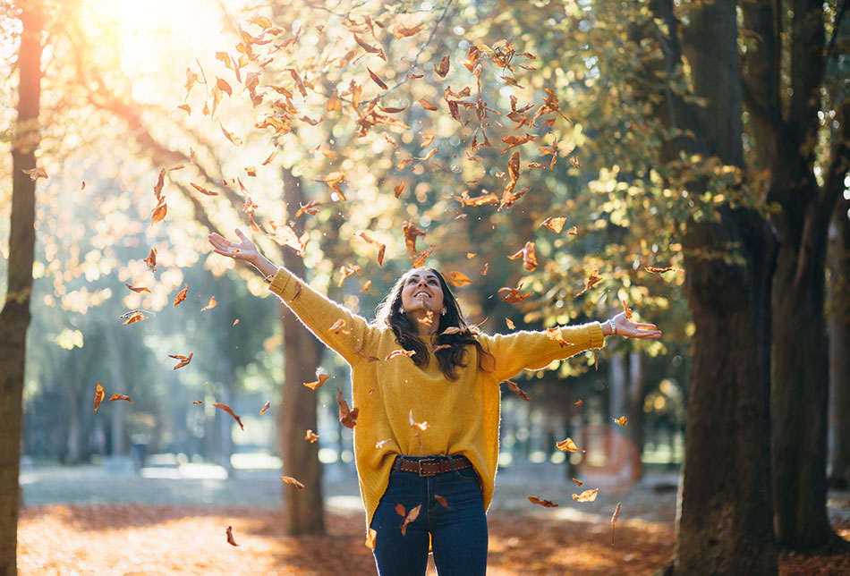 happy woman throwing leaves