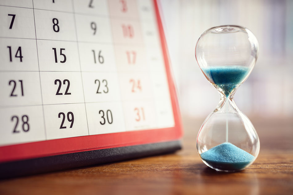 Hourglass with blue sand and calendar with red border