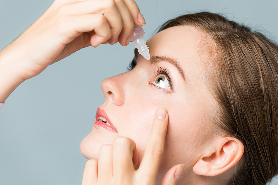 woman wearing contact lenses and using eye drops