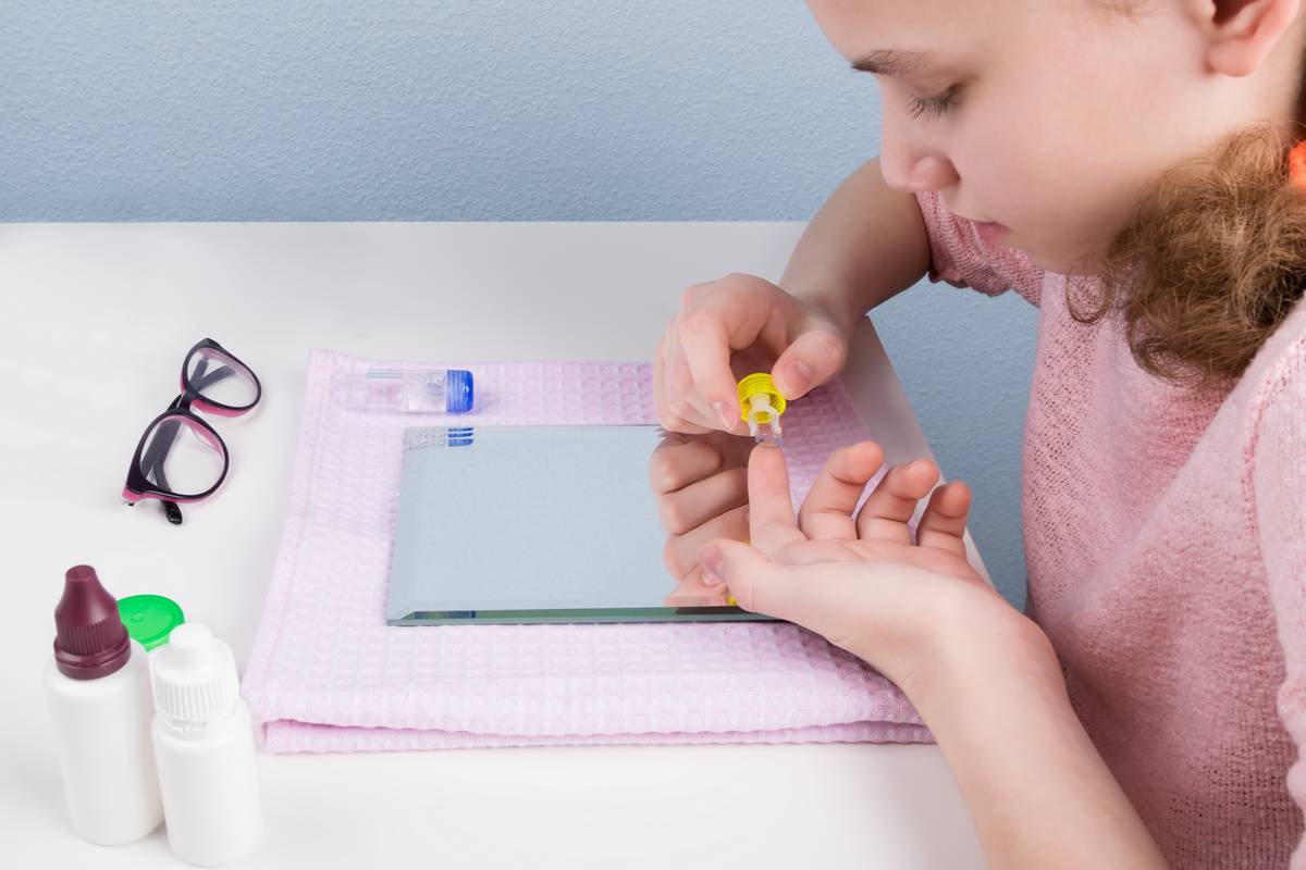 Little girl prepares to insert contact lenses