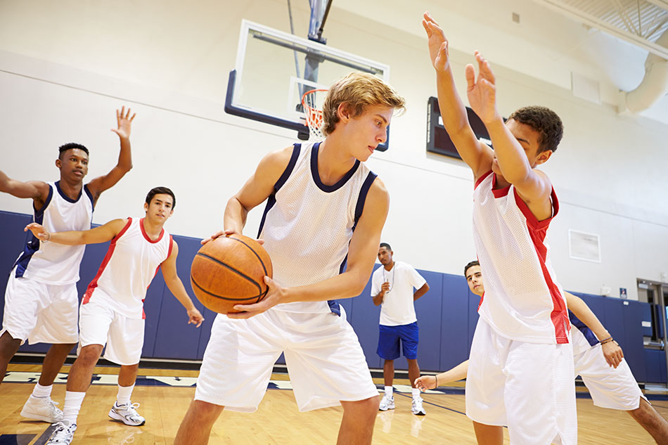 Male basketball team playing in dressed white jerseys