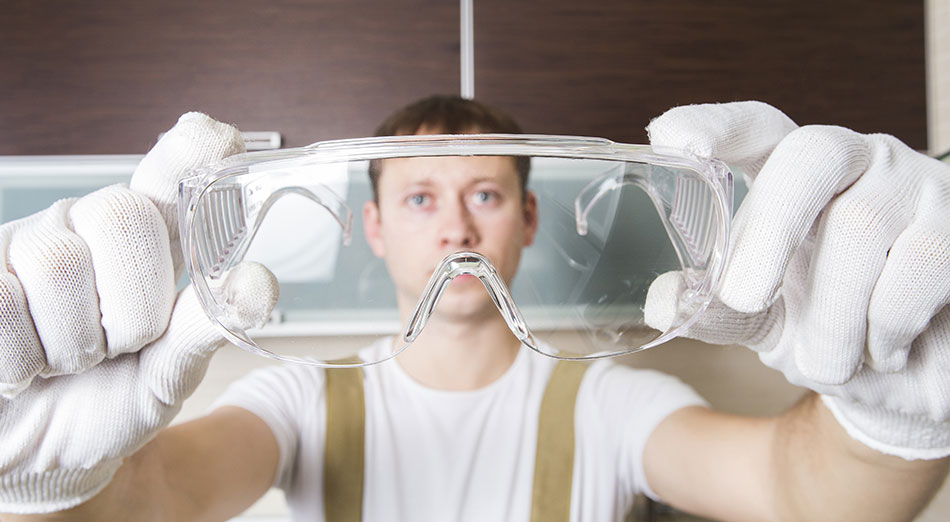 Male labourer showing eye protection glasses to avoid eye injuries