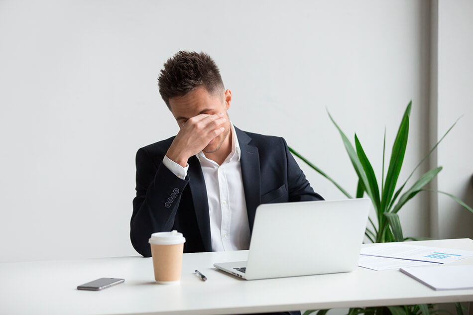 man at computer resting his eyes while getting used to contacts