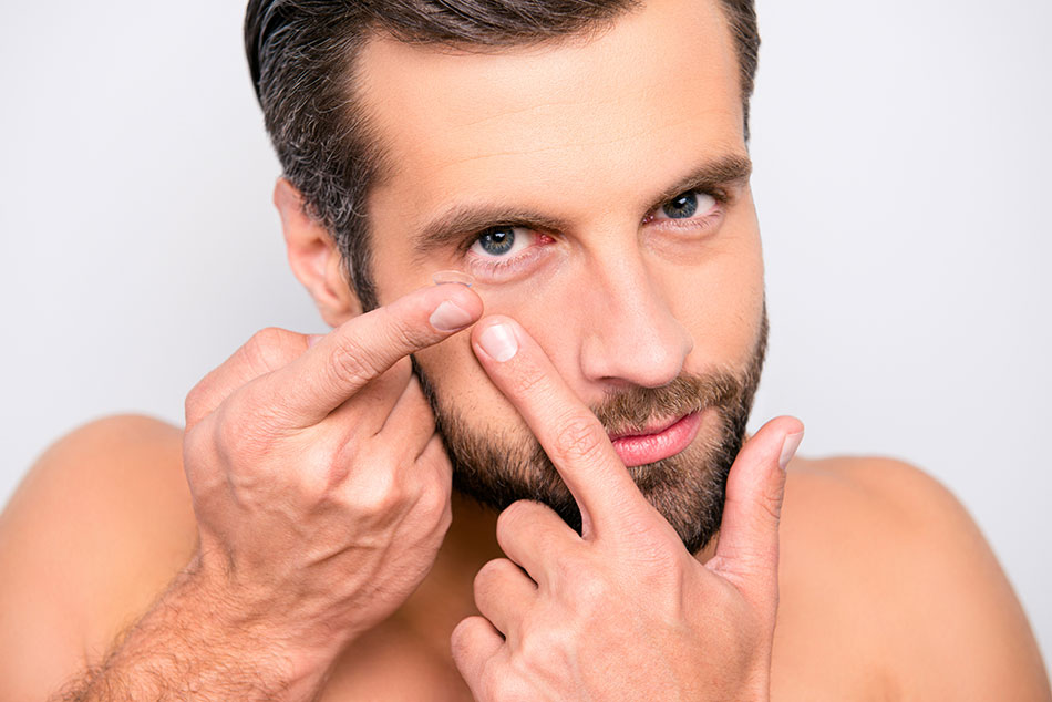 Man putting on contact lens