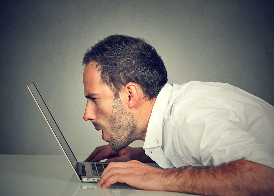 Man peering closely into computer screen