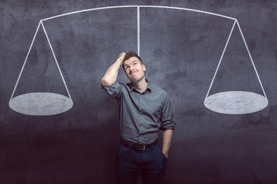 man scratching his head before drawing of scales