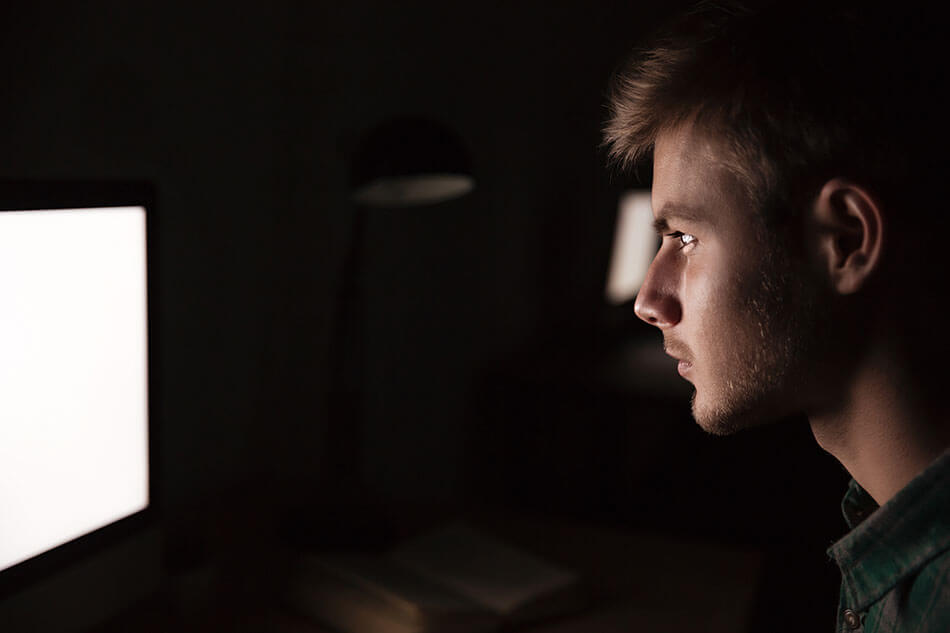 Man looking at bright computer screen