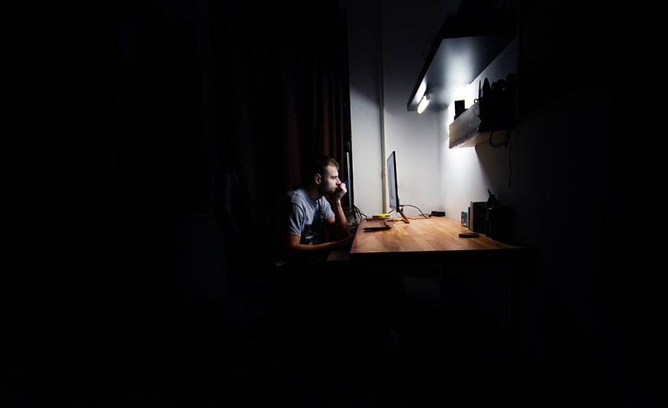 man in dark room using computer