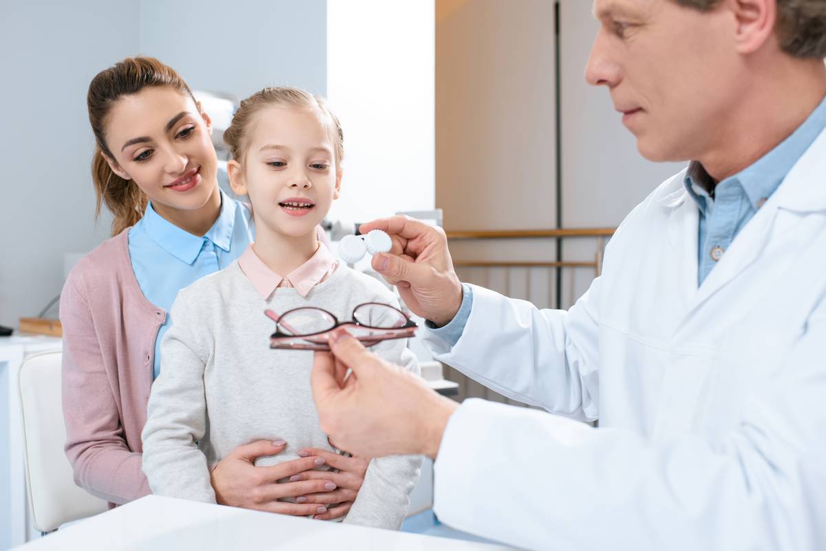 Mother and daughter choosing between contact lenses and glasses