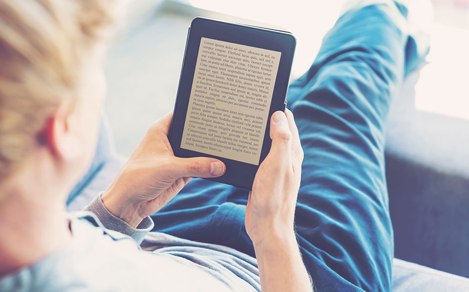 sitting man using contact lenses for reading on e-reader