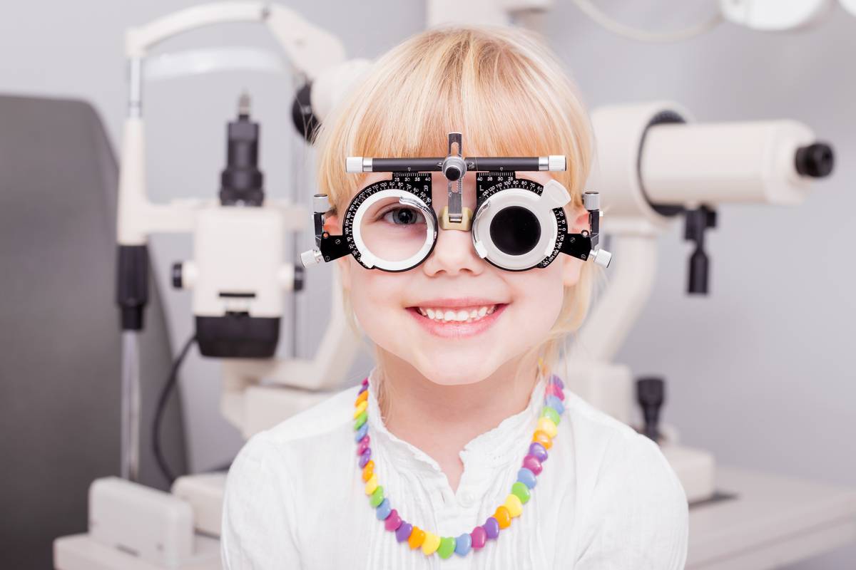 Small smiling child having eye exam