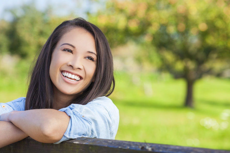 smiling brunette woman standing in field