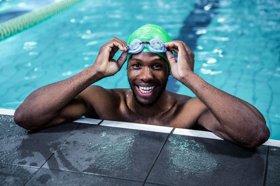 Smiling man with goggles in swimming pool