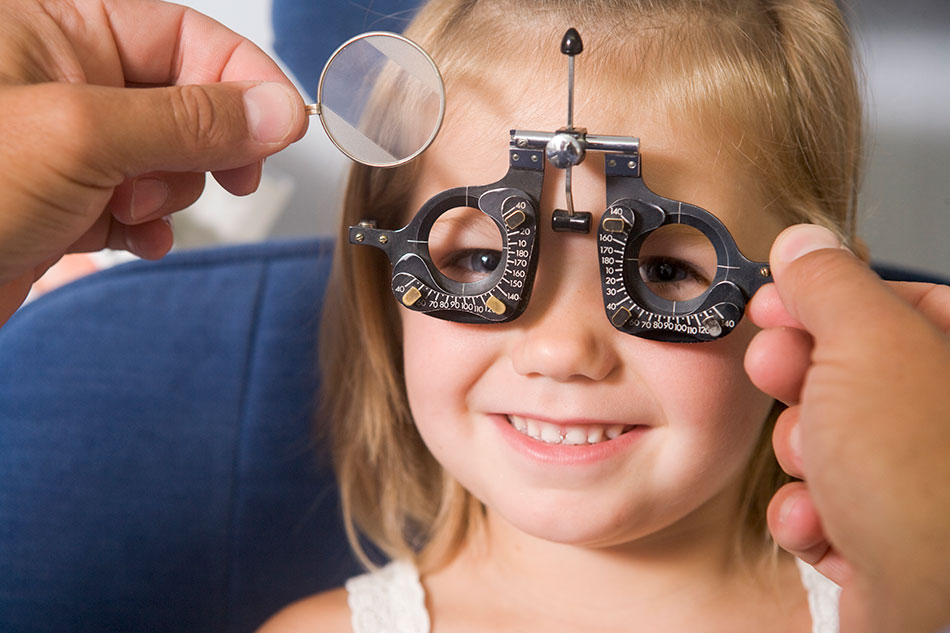 Smiling young girl being examined by optometrist