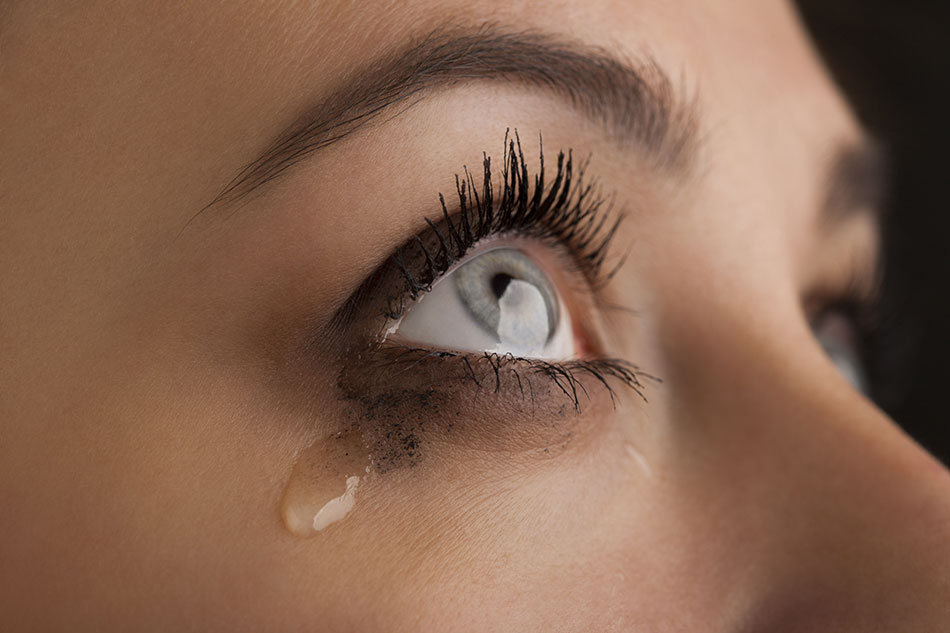 close-up of tear falling from woman’s eye