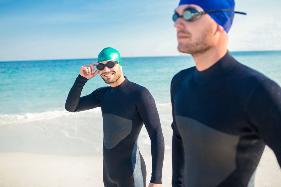 Two men wearing swimming goggles at the beach