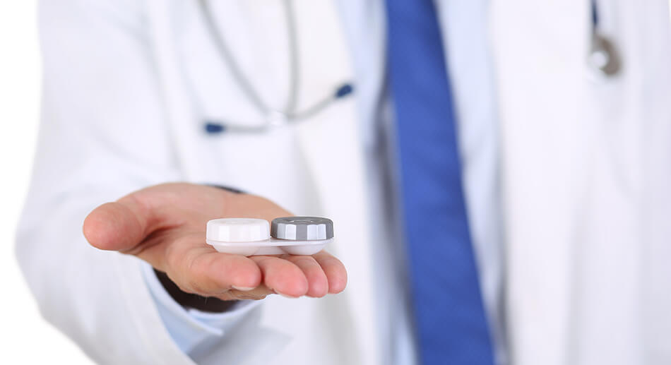 eye doctor with white coat and blue tie holding out contact case