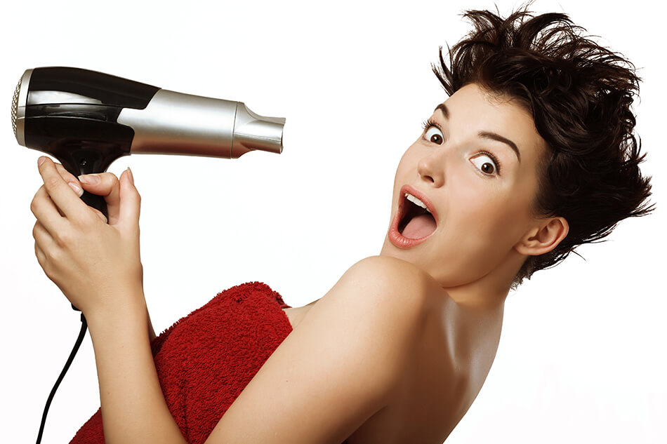 woman blow drying short hair