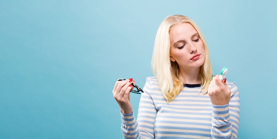 woman deciding between monthly contact lenses and glasses