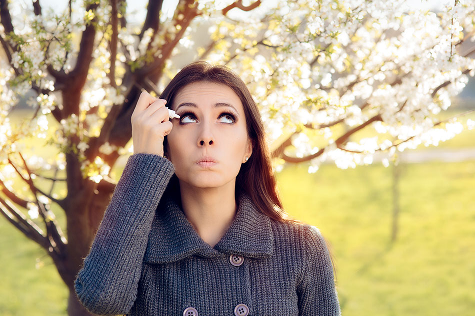 woman using eye drops outside