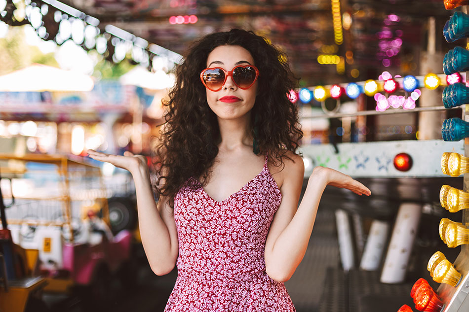 woman at fair with hands up, shrugging her shoulders