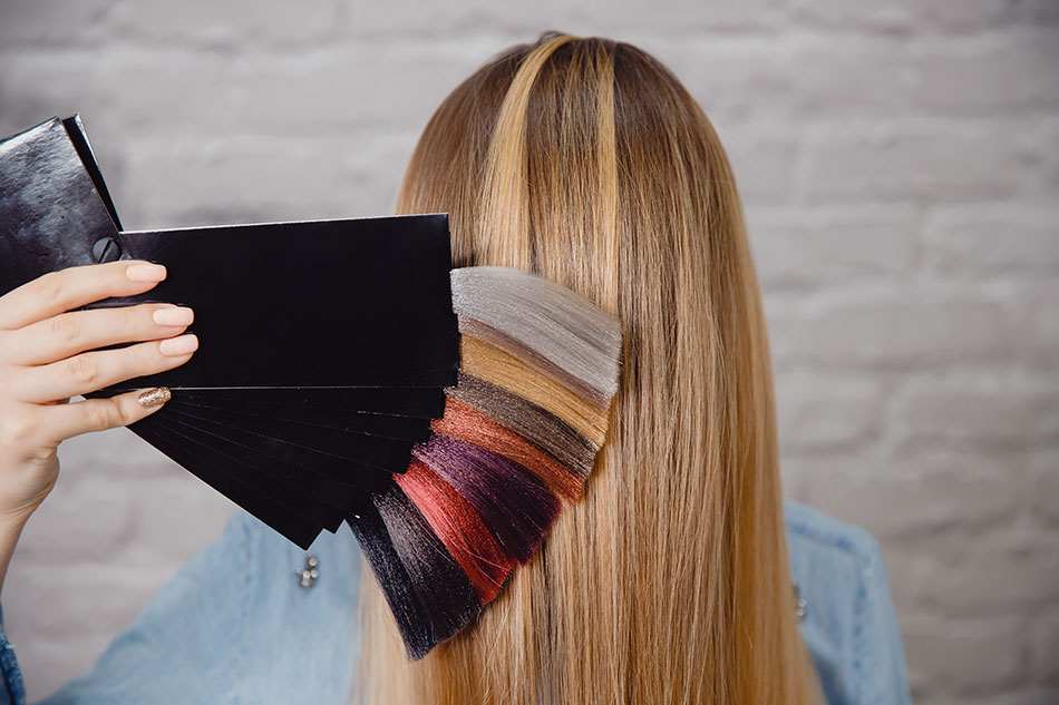 woman holding palette of hair colours against natural hair