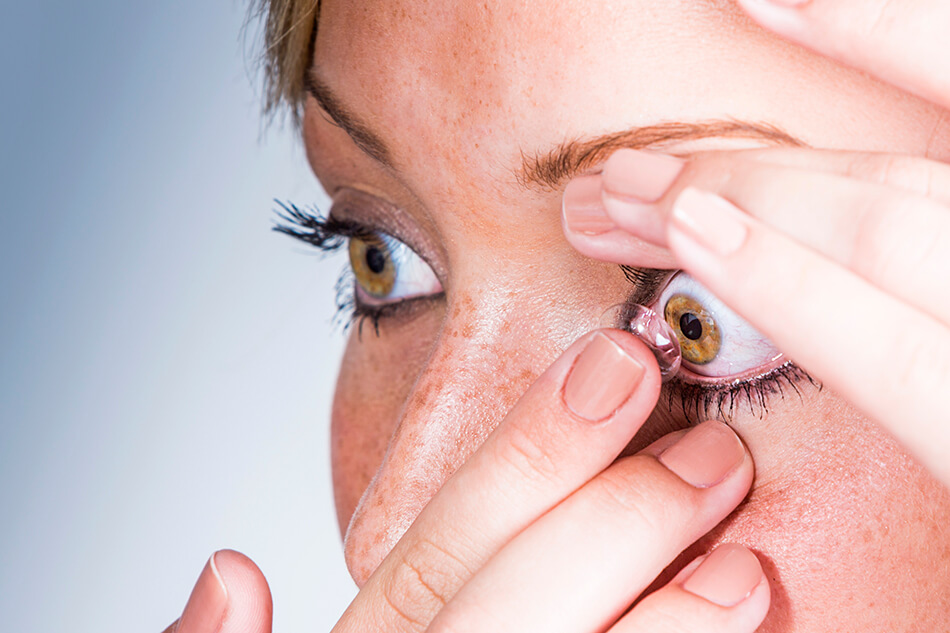 woman putting a contact lens into her eye