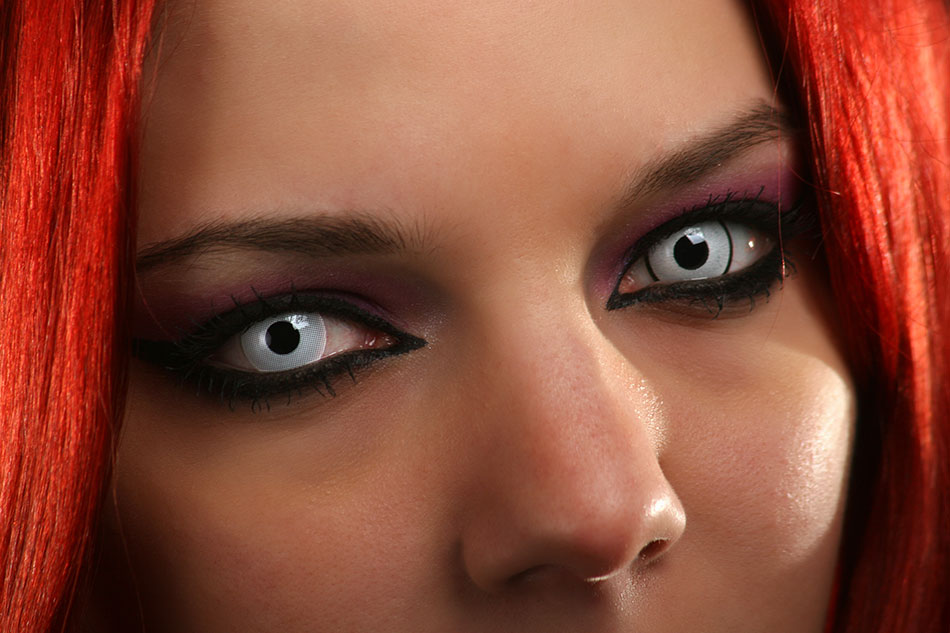 woman with red hair and white contact lenses