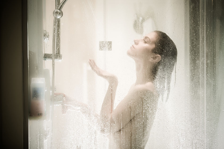 młoda kobieta biorąca prysznic z soczewkami kontaktowymi pod parującym prysznicem