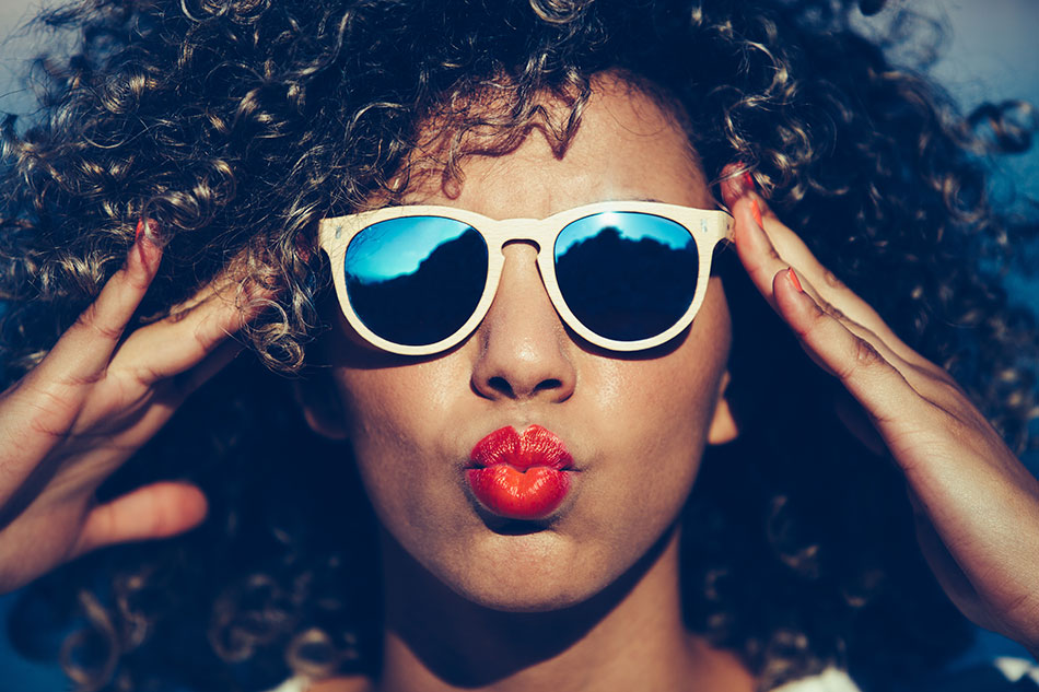 woman with sunglasses blowing kiss