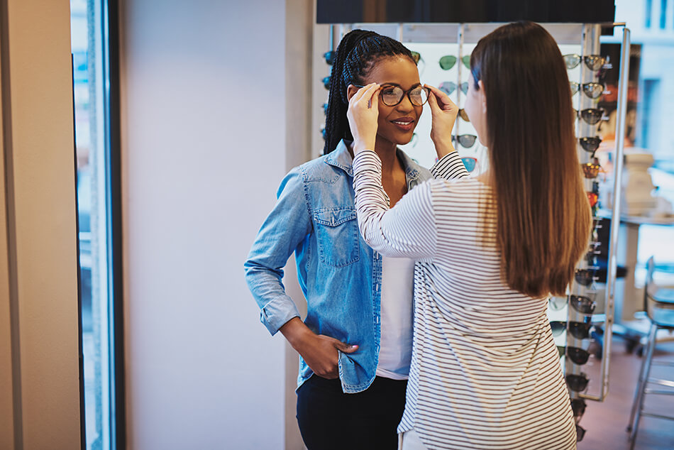 young woman being fitted for glasses by vision care professional