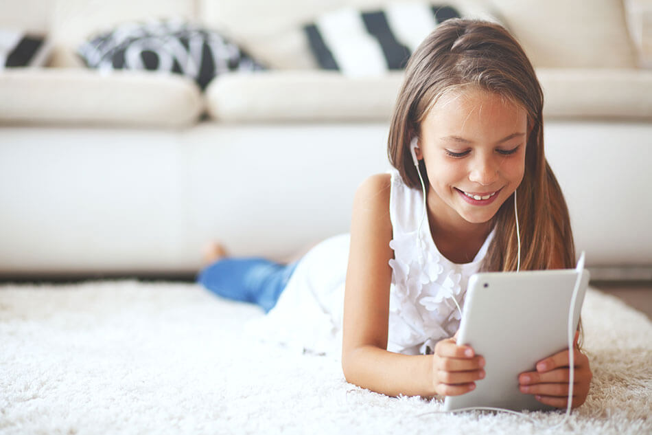 Young girl smiling while on her tablet